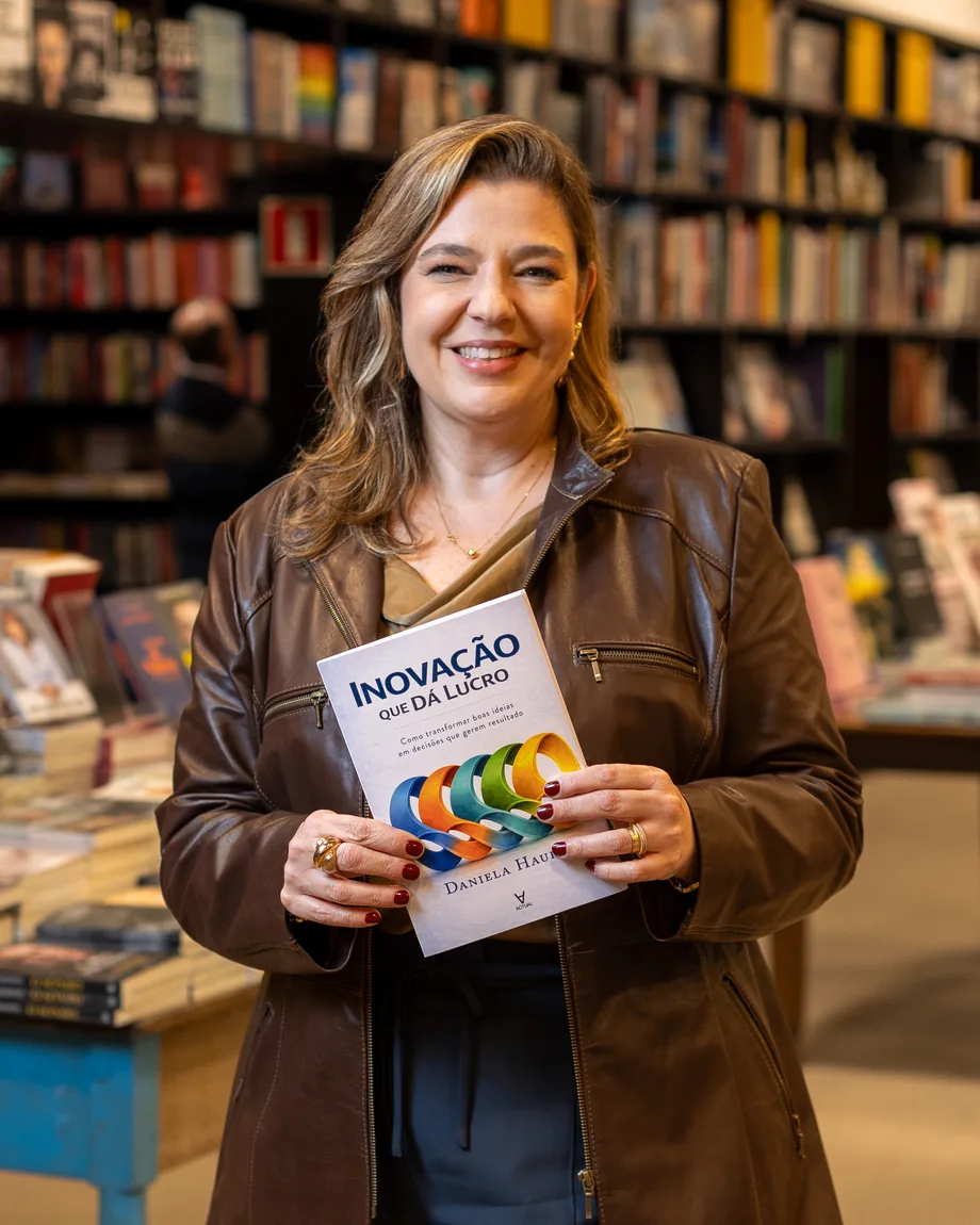 Daniela Hauffe segurando o livro Inovação que Dá Lucro no lançamento em livraria